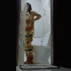 A hidden camera records an Asian woman as she takes a shit while sitting on a toilet as viewed from an open bathroom door. She rinses her ass with a bucket of water and cleans the toilet when finished. Vertical format video. Over 2 minutes.